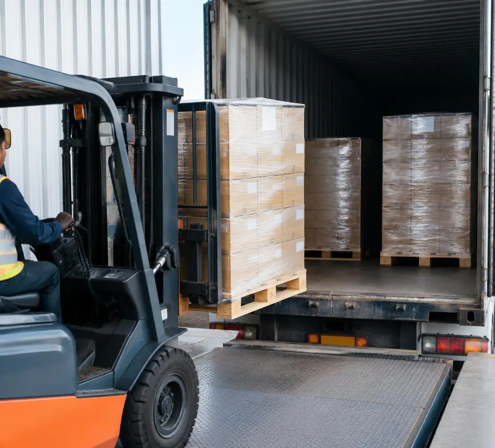 Pallets wrapped in transparent stretch film being loaded into a truck